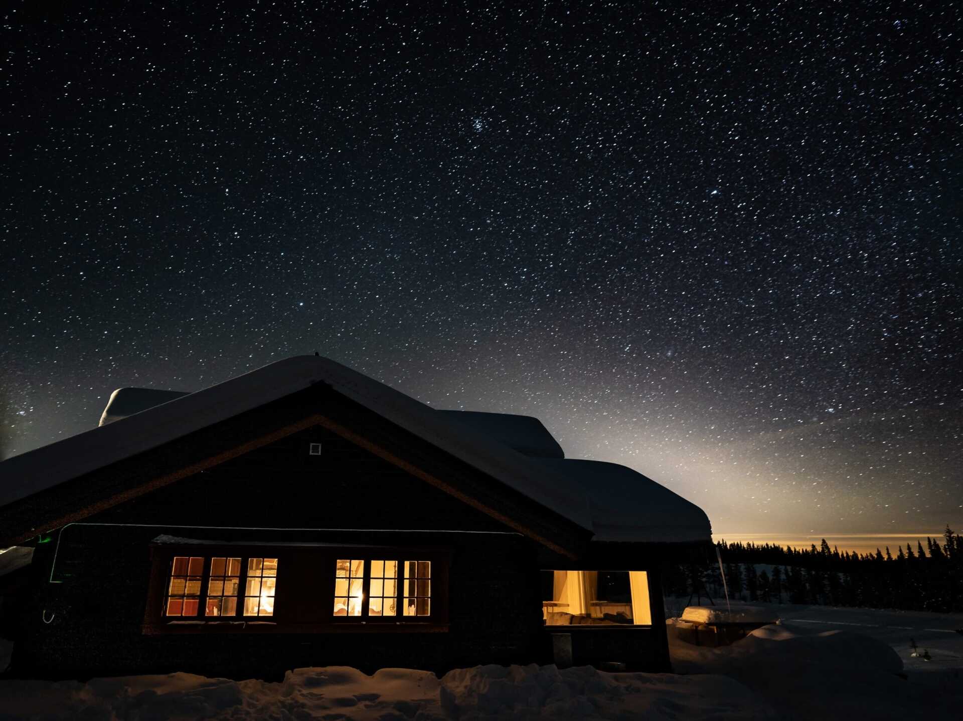 The lodge lit up at night beneath a starry sky