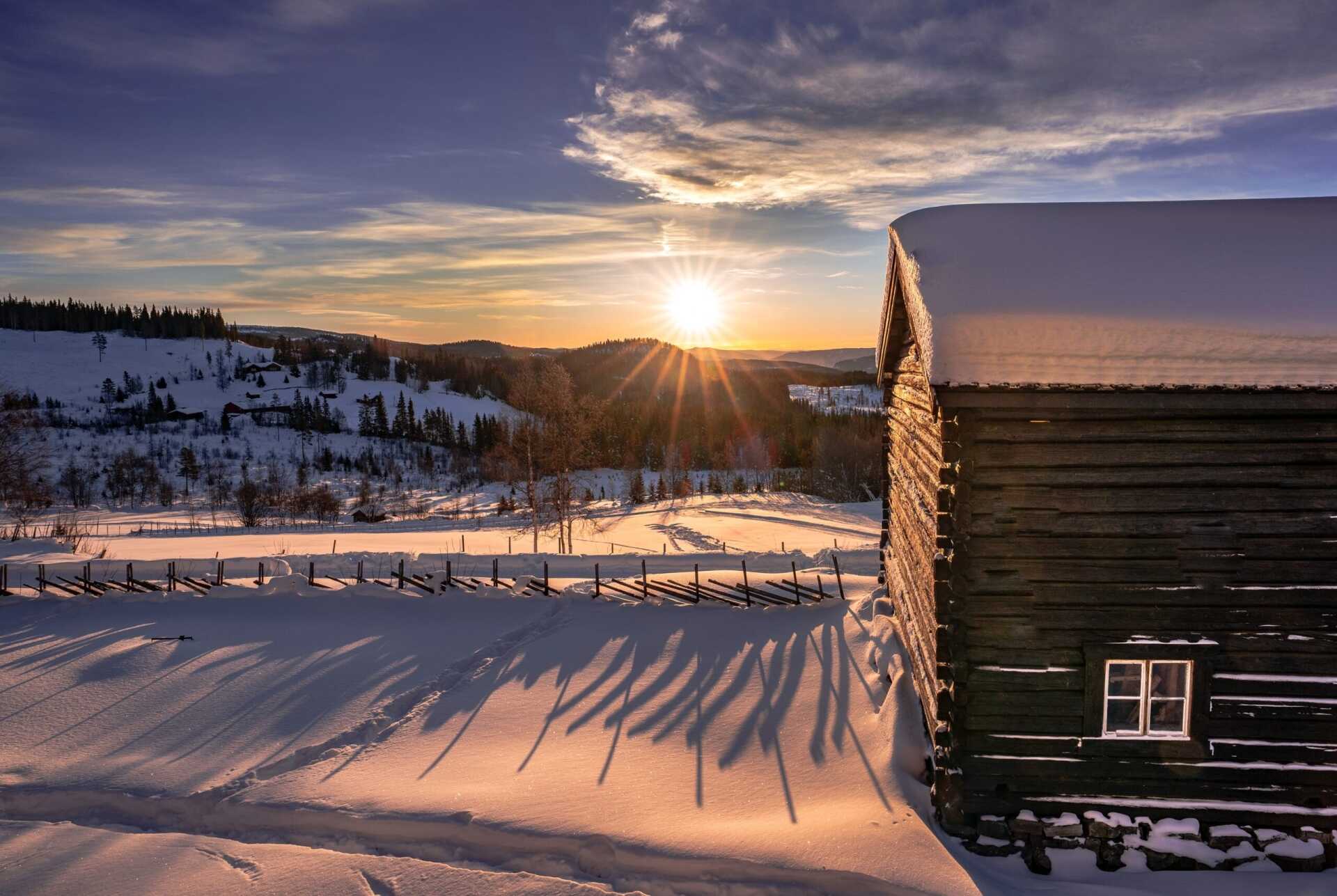 Timber buildings in snow at sunset