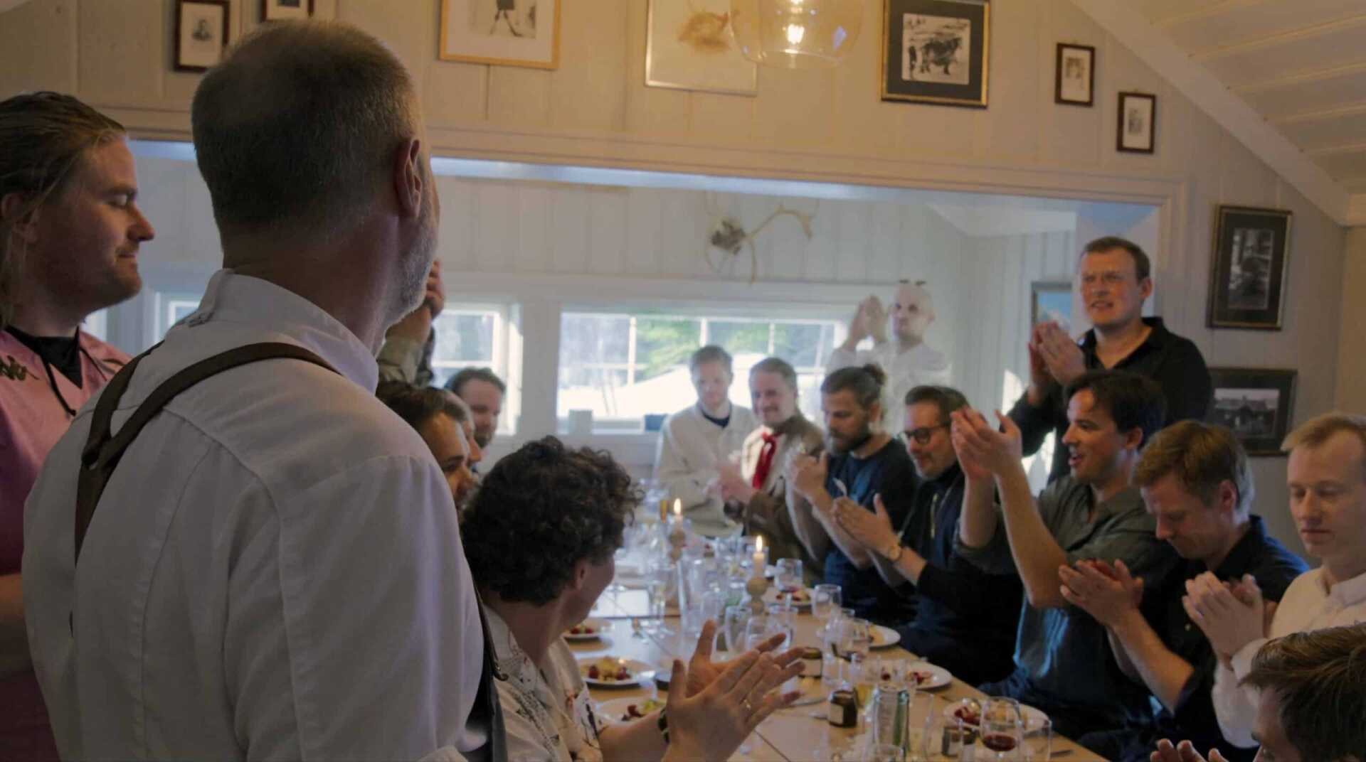 Guests applauding around the wedding table