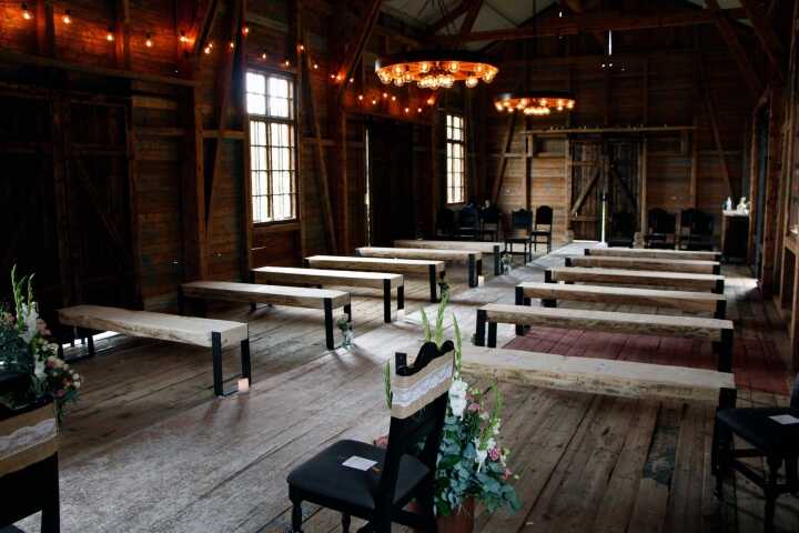 The barn set with benches and long tables under a chandelier