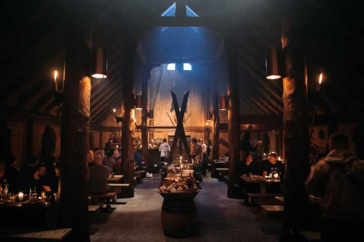 The barn at night, lit around a central open fire