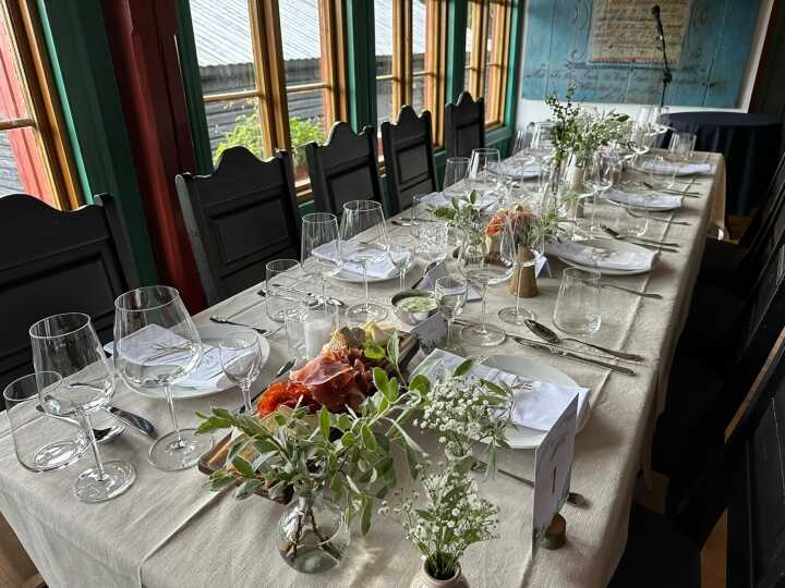 A long table dressed with flowers and glassware for a dinner